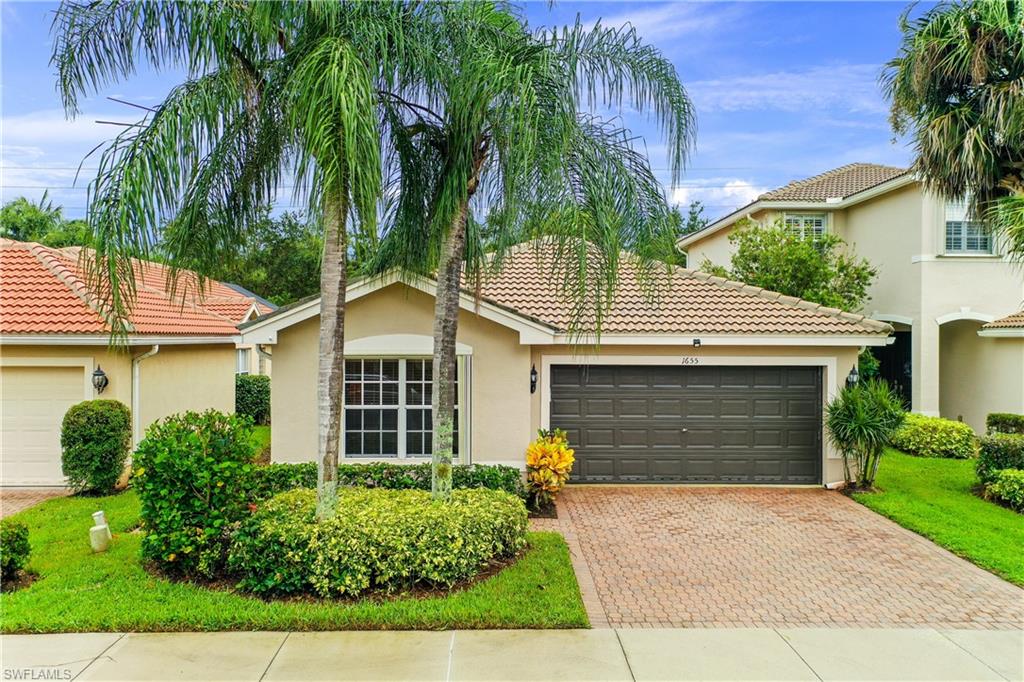 1655 Triangle Palm Terrace Naples, FL 34119 - Photo 1 of 22 a front view of a house with a yard