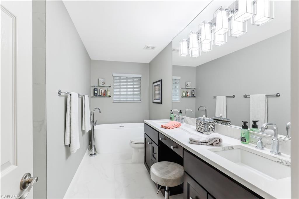 1655 Triangle Palm Terrace Naples, FL 34119 - Photo 12 of 22 a dining room with stainless steel appliances kitchen island a table chairs and couches