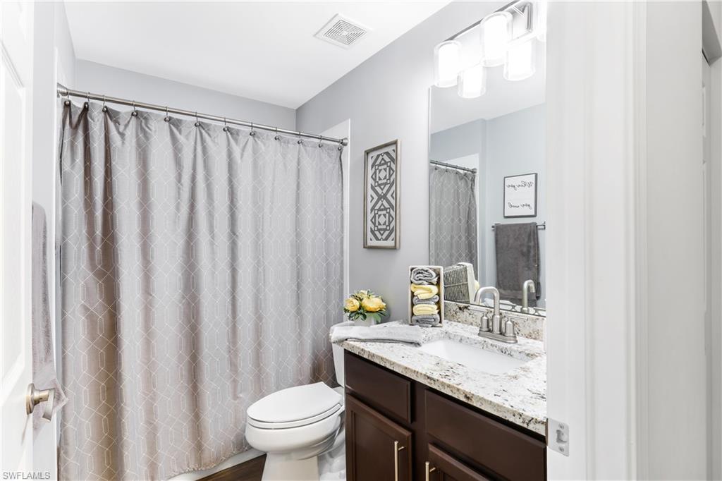 1655 Triangle Palm Terrace Naples, FL 34119 - Photo 15 of 22 a bathroom with a granite countertop sink toilet and a mirror