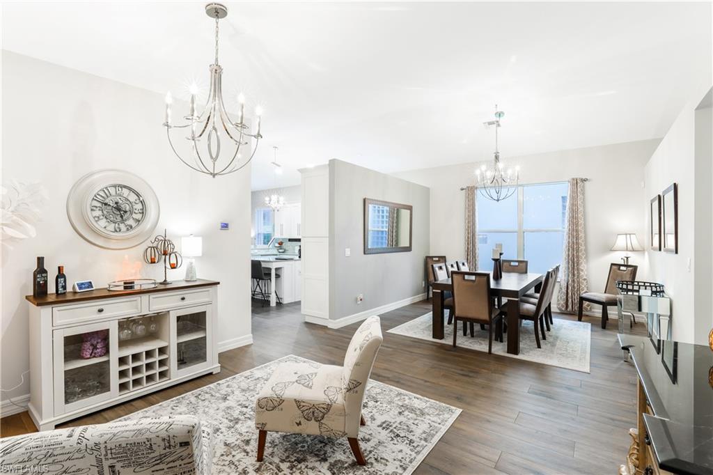 1655 Triangle Palm Terrace Naples, FL 34119 - Photo 5 of 22 a view of a dining room and livingroom with furniture wooden floor a chandelier