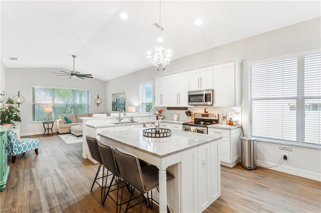 1655 Triangle Palm Terrace Naples, FL 34119 - Photo 7 of 22 a view of kitchen with sink stove and wooden floor