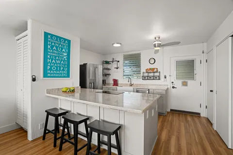 a kitchen with a sink cabinets and wooden floor