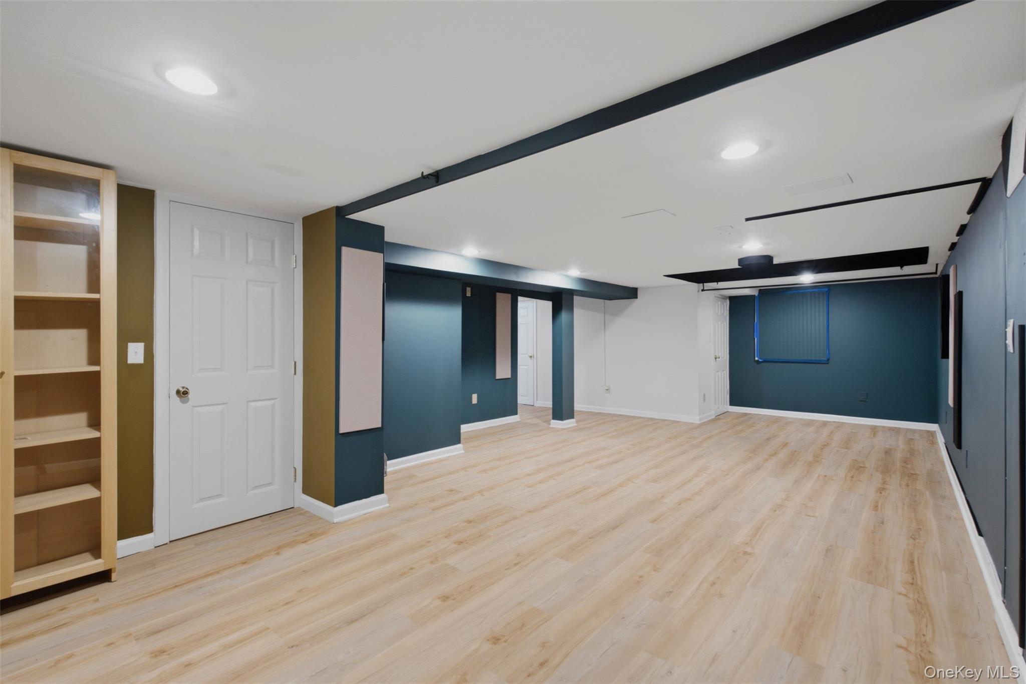 12 Leeside Road Carmel, NY 10512 - Photo 29 of 44 Spacious basement room featuring light wood-finish flooring, recessed lighting, accent walls, built-in shelving, and white trim