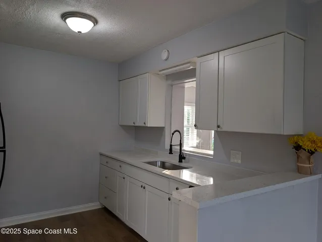 a kitchen with a sink cabinets and window