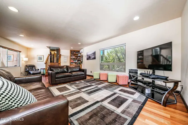 a view of stairs and an empty room with wooden floor
