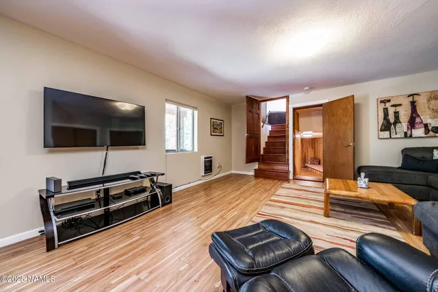 a kitchen with stainless steel appliances kitchen island granite countertop a refrigerator a stove top oven a sink dishwasher and white cabinets with wooden floor