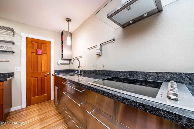 a kitchen with stainless steel appliances a dining table chairs stove and refrigerator