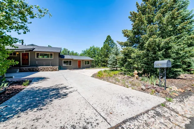 front view of a house with a yard and potted plants
