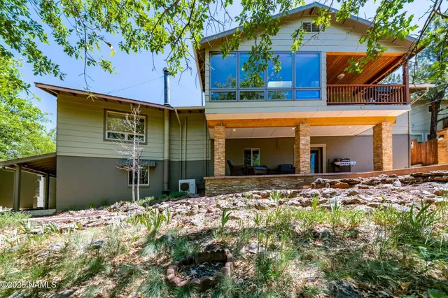 a living room with furniture a large window and wooden floor