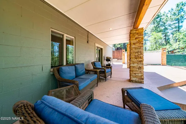 a view of a patio with a table and chairs under an umbrella