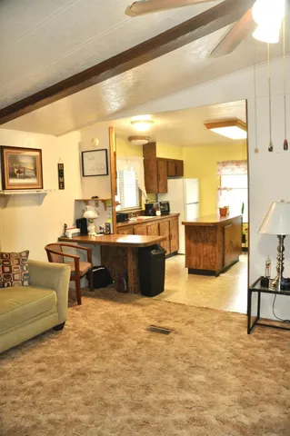 a living room with couches and kitchen view with wooden floor