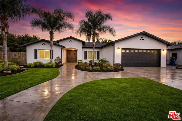 a front view of a house with a garden and yard