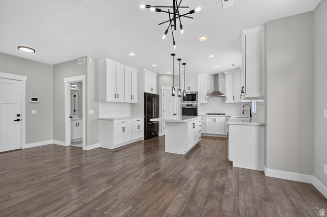 36 West Syracuse Road Vineyard, UT 84059 - Photo 14 of 56 Contemporary open-concept kitchen featuring white cabinetry, an island with pendant lighting, stainless steel appliances, and wood-finish flooring