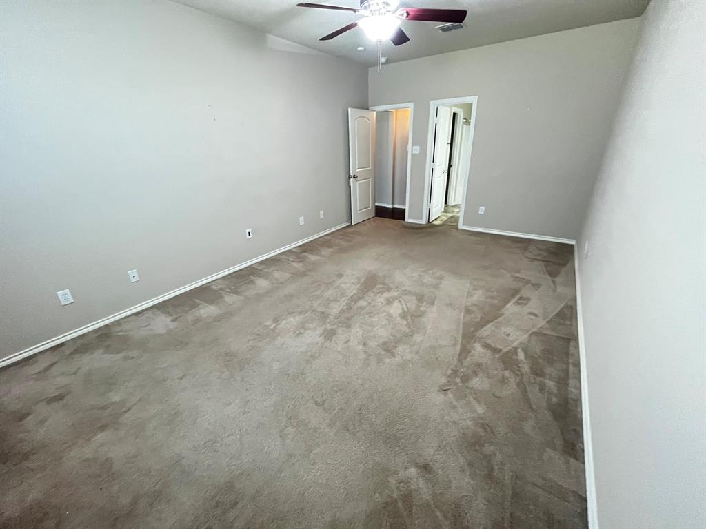 129 Sierra Drive Waxahachie, TX 75167 - Photo 17 of 24 an empty room with a chandelier fan and windows