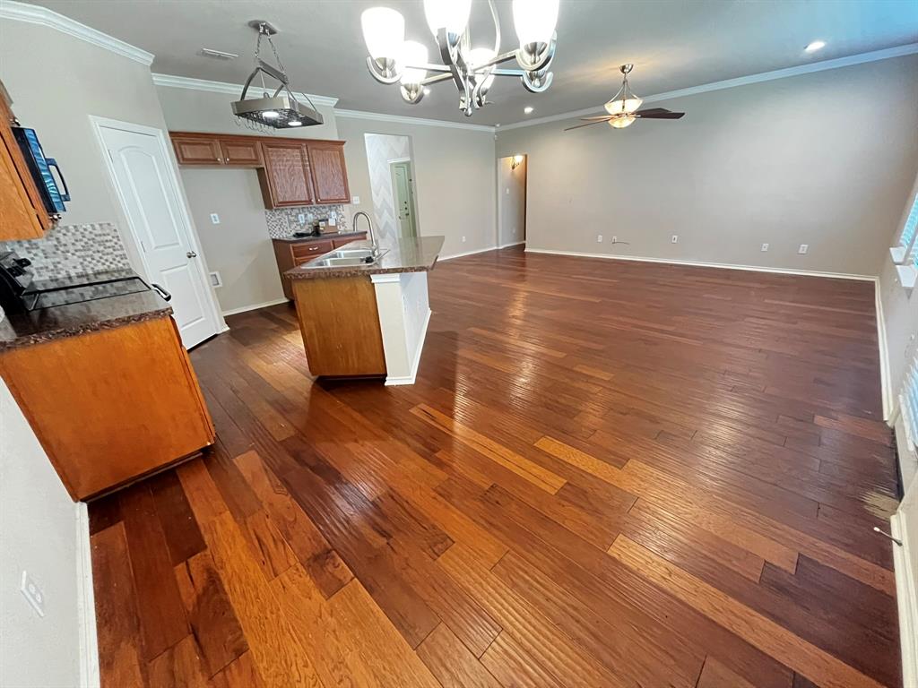 129 Sierra Drive Waxahachie, TX 75167 - Photo 7 of 24 an empty room with wooden floor and chandelier
