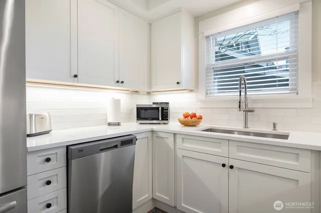 a kitchen with white cabinets and white appliances