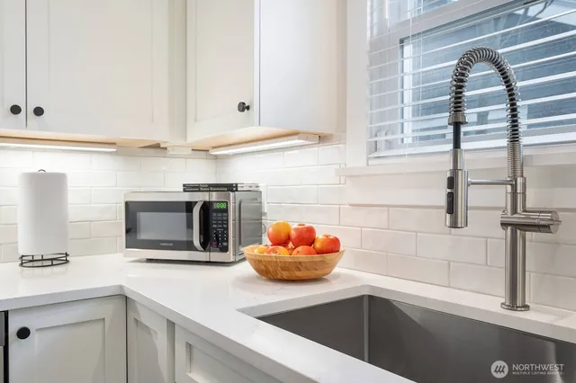 a kitchen with stainless steel appliances a refrigerator and wooden floor