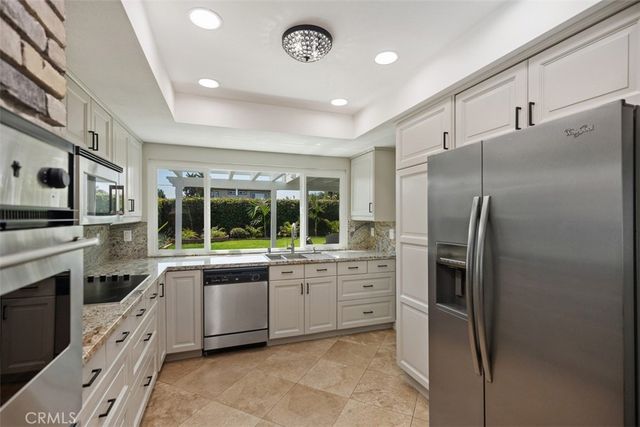a kitchen with stainless steel appliances granite countertop a refrigerator sink and stove