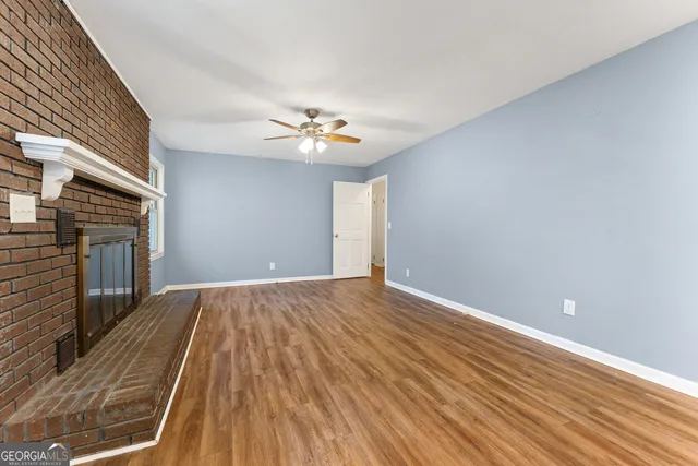 a view of a kitchen with wooden floor and a ceiling fan
