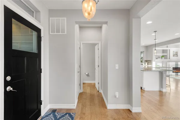 a view of a hallway with wooden floor windows and a kitchen