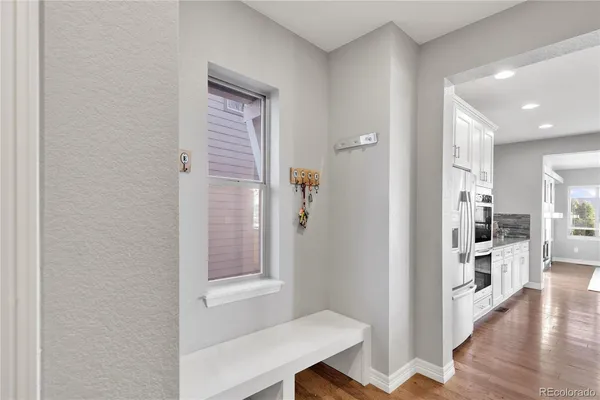 a view of a hallway with wooden floor and a living room