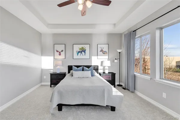 a bedroom with a large bed and a chandelier fan