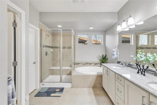 a bathroom with a granite countertop sink a toilet a mirror a bathtub and shower