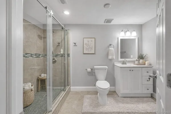 a bathroom with a toilet sink a shower and a mirror