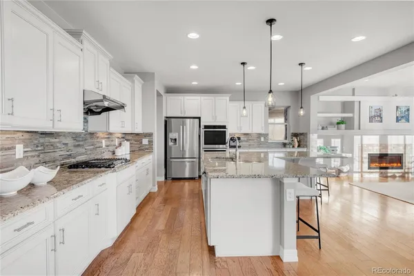 a kitchen with stainless steel appliances kitchen island granite countertop a stove a sink and a refrigerator
