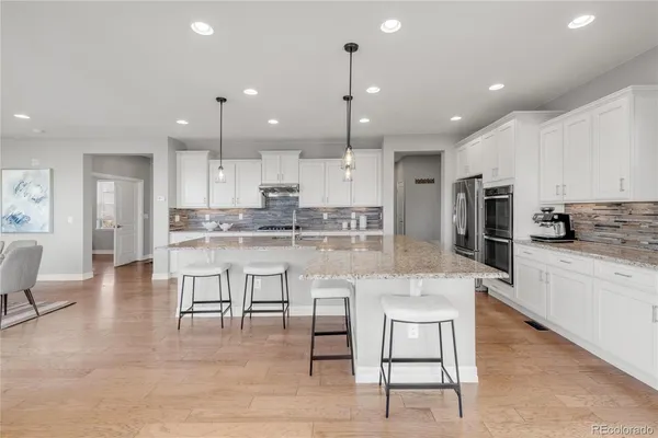 a large kitchen with cabinets table and chairs