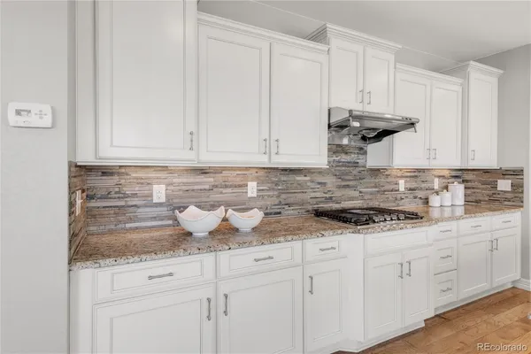 a kitchen with white cabinets and white appliances