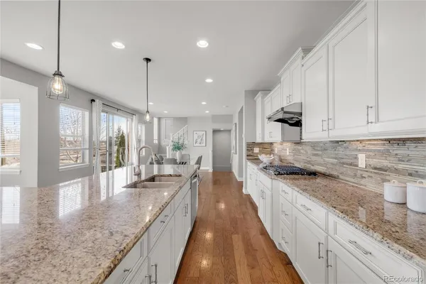 a large kitchen with stainless steel appliances granite countertop a lot of counter space and a sink