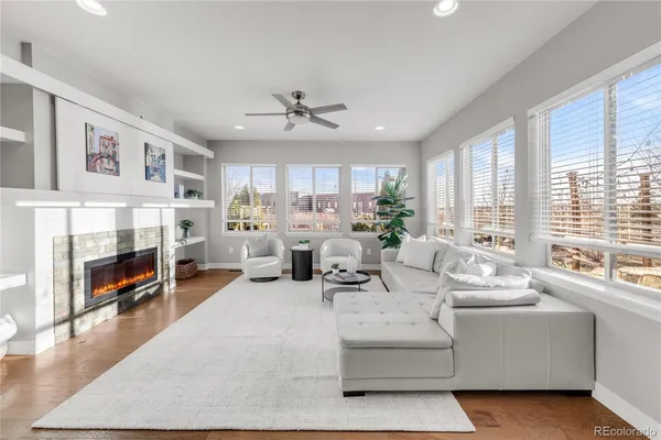 a living room with furniture fireplace and a large window