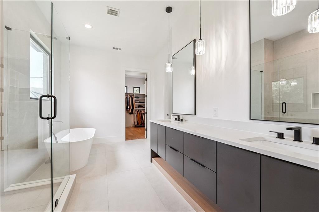 2551 Kilgore Road Buford, GA 30519 - Photo 17 of 45 a bathroom with a double vanity sink a toilet a mirror and shower