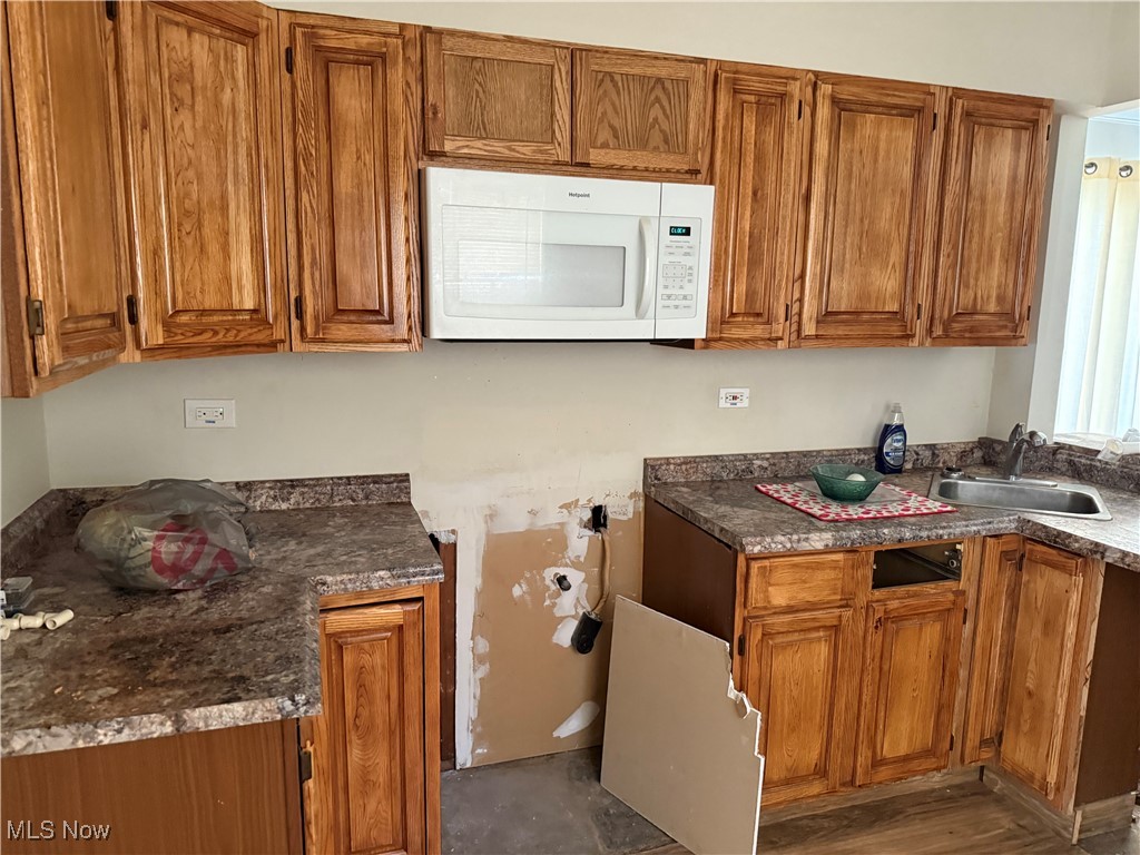 1877 Clyde Road Madison, OH 44057 - Photo 2 of 19 Kitchen with brown cabinetry and white microwave