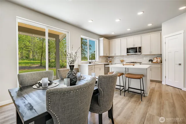 a kitchen with kitchen island white cabinets and refrigerator