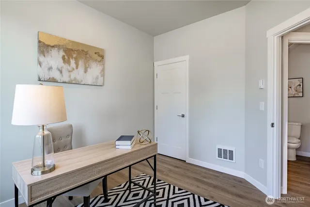 a view of a workspace with furniture and a window
