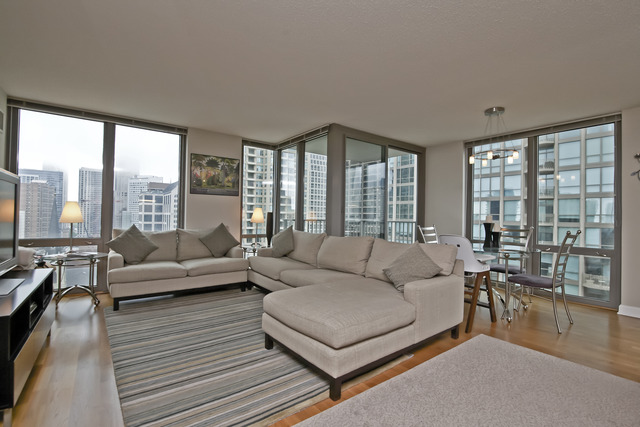2 East Erie Street, Unit 1611 Chicago, IL 60611 - Photo 2 of 12 a living room with furniture and a large window
