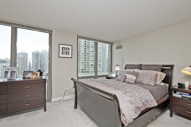 2 East Erie Street, Unit 1611 Chicago, IL 60611 - Photo 6 of 12 a bedroom with a bed and a large window