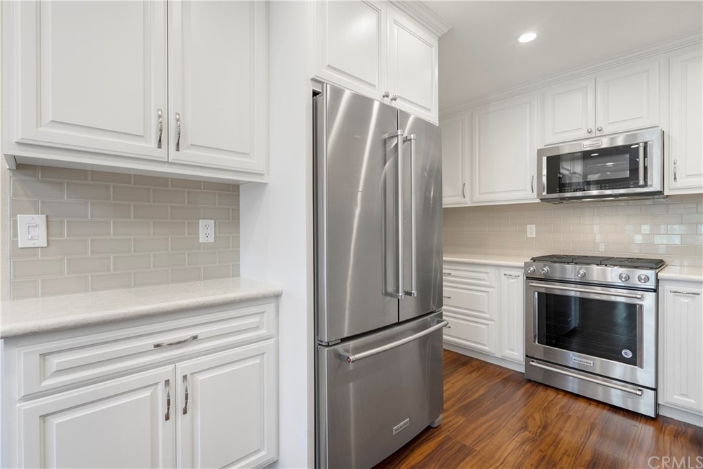 5965 Maybrook Circle Riverside, CA 92506 - Photo 14 of 34 a kitchen with stainless steel appliances white cabinets and a stove top oven