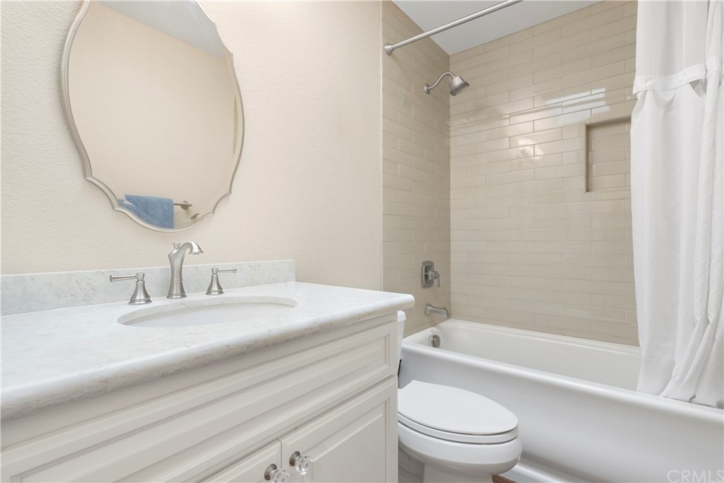 5965 Maybrook Circle Riverside, CA 92506 - Photo 21 of 34 a bathroom with a granite countertop bathtub shower sink vanity mirror and toilet
