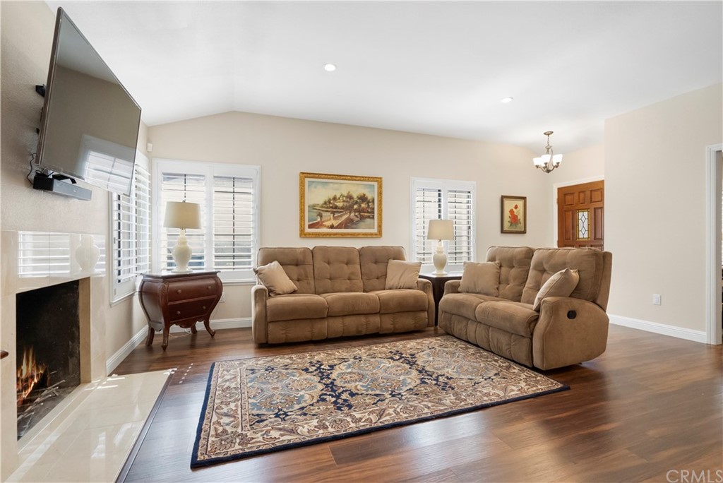 5965 Maybrook Circle Riverside, CA 92506 - Photo 9 of 34 a living room with furniture a fireplace a flat screen tv and windows