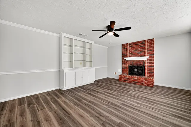 a view of empty room with wooden floor and fireplace