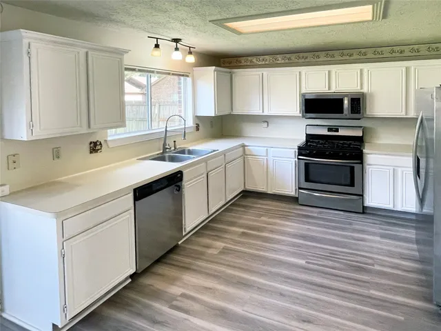 a kitchen with a sink stove and microwave