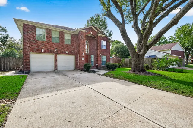 a front view of a house with a yard and an trees