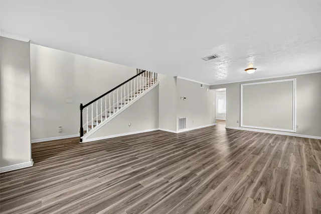 a view of empty room with wooden floor