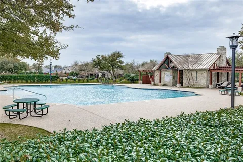 a front view of a house with a yard and fountain in middle