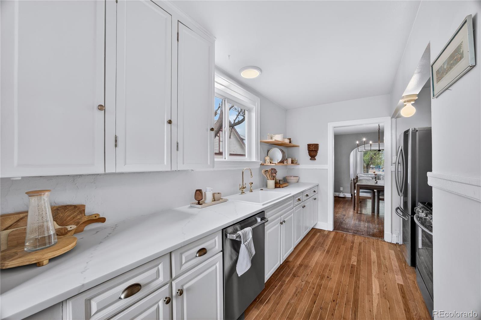6730 Oneida Street Commerce City, CO 80022 - Photo 14 of 37 a kitchen with a white cabinets and stainless steel appliances