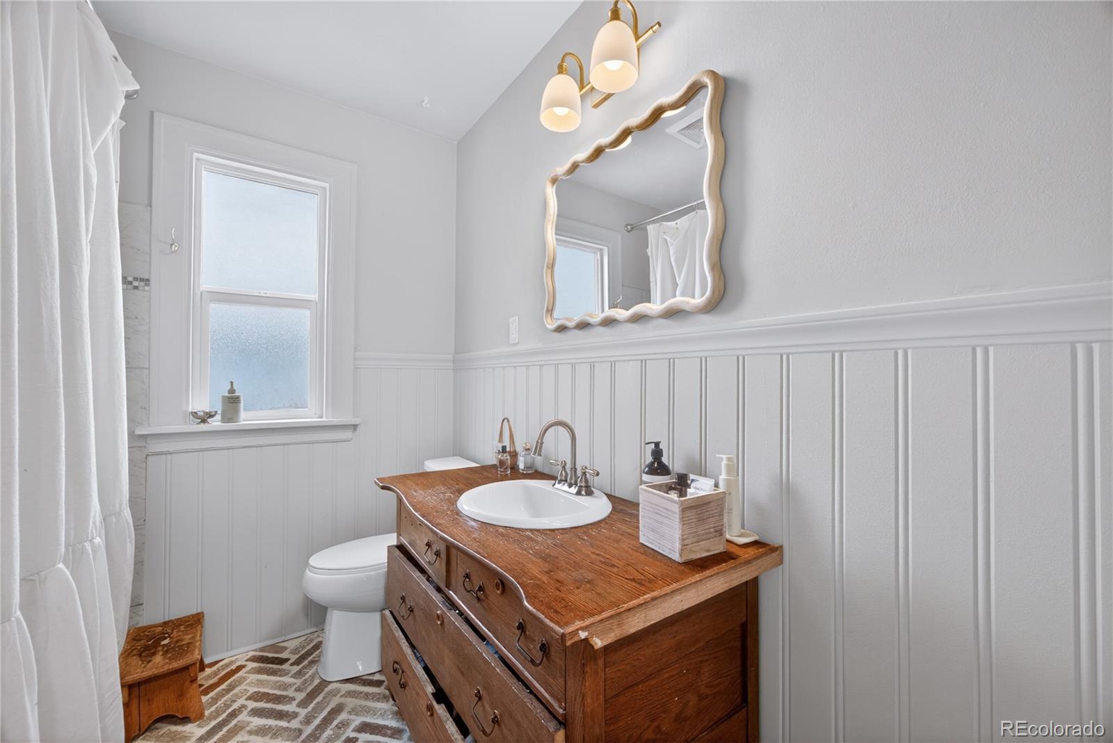6730 Oneida Street Commerce City, CO 80022 - Photo 18 of 37 a bathroom with a sink a mirror and a toilet