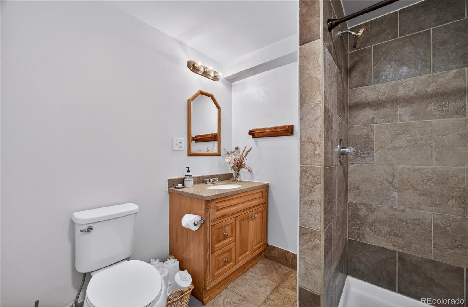 6730 Oneida Street Commerce City, CO 80022 - Photo 23 of 37 a bathroom with a granite countertop toilet sink and shower